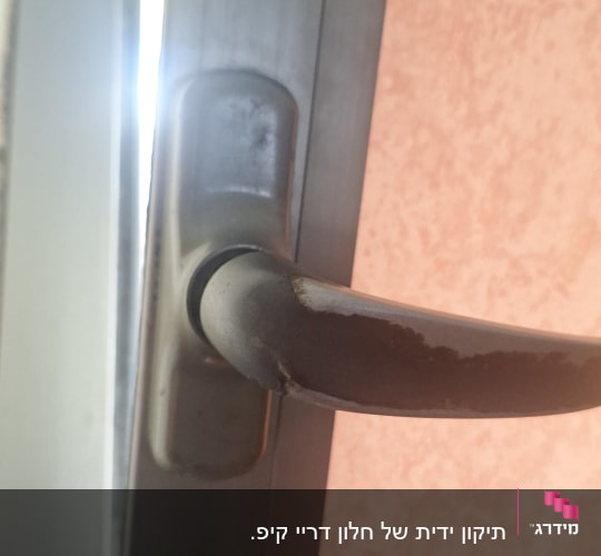 ידית חלון מתכתית עם תריסים ברקע